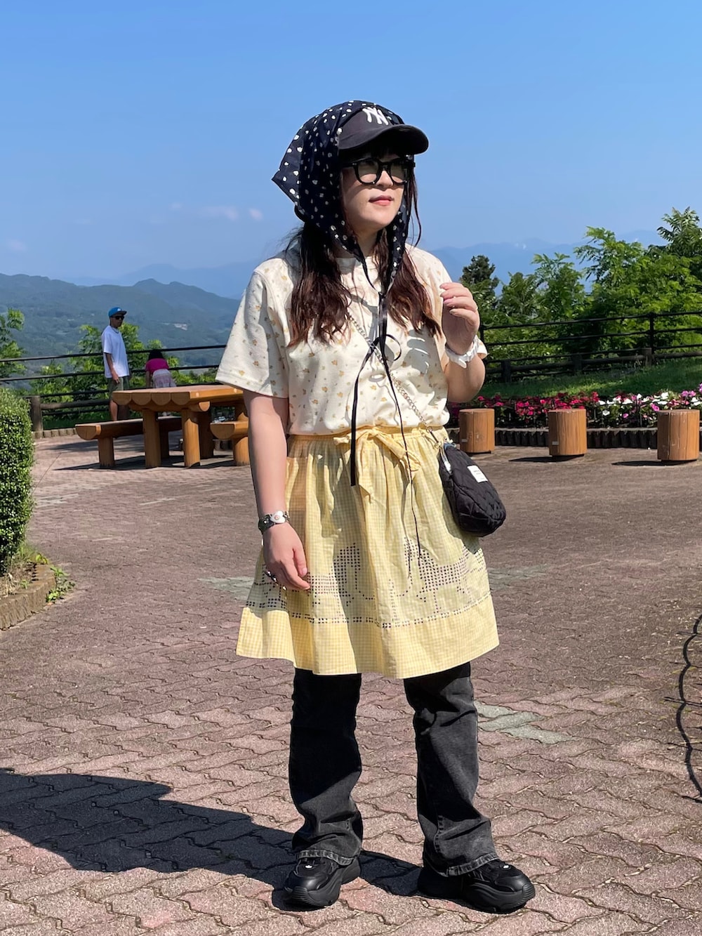 ホワイト系のTシャツ/カットソー、ブラック系のスニーカー、ブラック系のショルダーバッグを着用したレディースの夏コーディネートの2枚目の写真