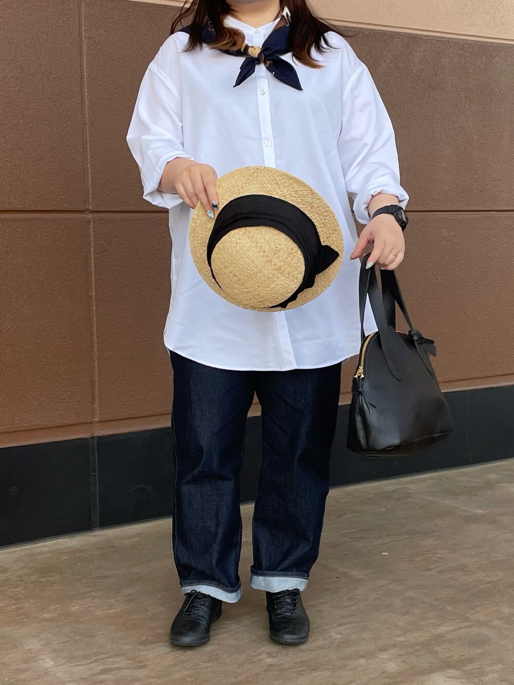 ブラック系のボストンバッグ、ブラック系のハットを着用したレディースの春コーディネートの2枚目の写真