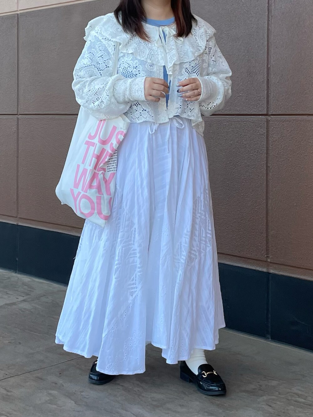 ホワイト系のスカート、ホワイト系のトートバッグ、ブルー系のTシャツ/カットソーを着用したレディースの春コーディネートの2枚目の写真
