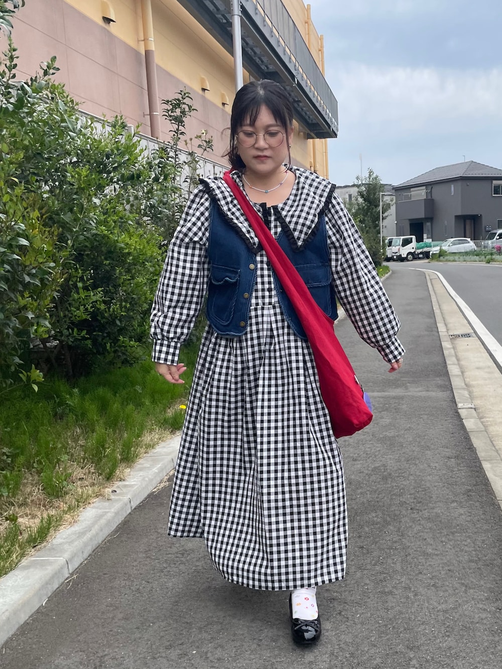 レッド系のショルダーバッグ、シルバー系のピアス（両耳用）を着用したレディースの春コーディネートの2枚目の写真