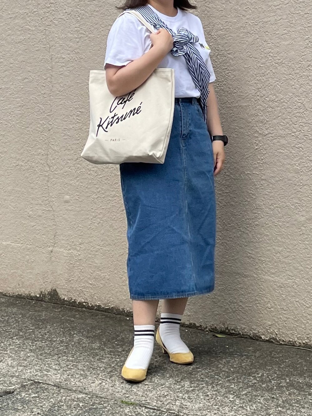 ホワイト系のTシャツ/カットソー、ブルー系のデニムスカート、イエロー系のパンプスを着用したレディースの夏コーディネートの2枚目の写真