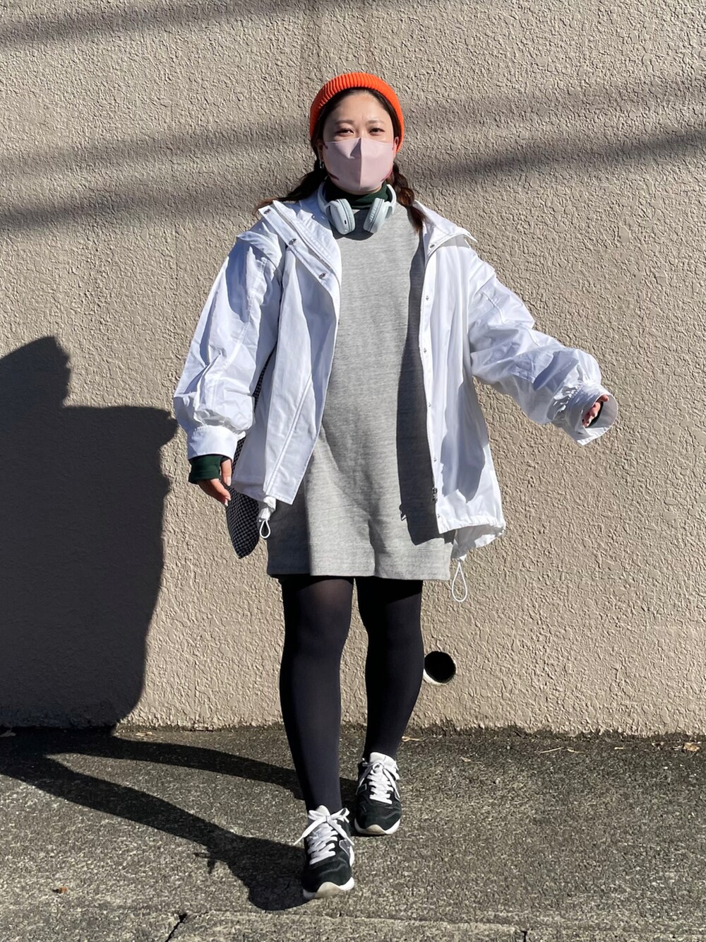 グレー系のワンピース、ブルー系のスニーカー、ホワイト系のブルゾンを着用したレディースの冬コーディネートの3枚目の写真