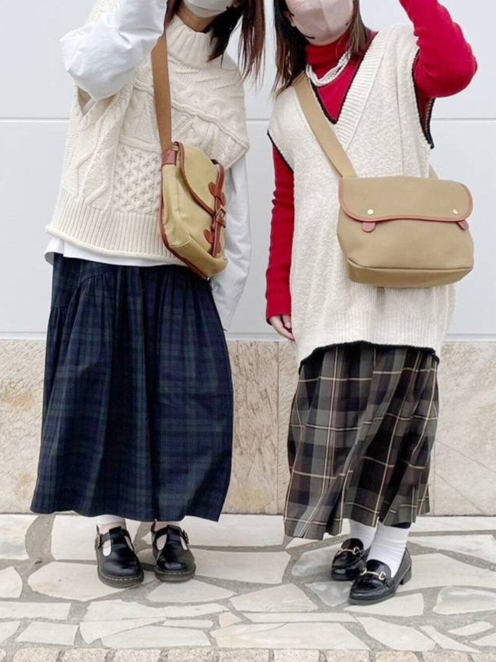 レッド系のニット/セーター、ホワイト系のベスト、グリーン系のスカートを着用したレディースの冬コーディネートの2枚目の写真