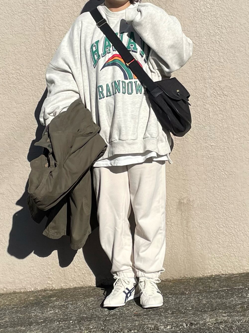 グリーン系のモッズコート、ホワイト系のスウェットパンツ、ホワイト系のスウェットを着用したレディースの冬コーディネートの3枚目の写真