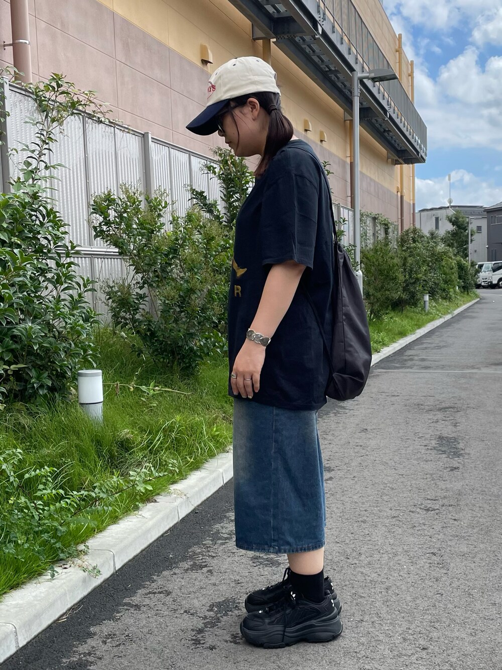 ブラック系のTシャツ/カットソー、ブルー系のパンツ、ブラック系のスニーカーを着用したレディースの夏コーディネートの2枚目の写真
