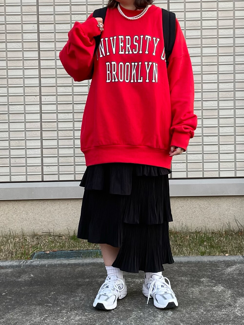 レッド系のスウェット、ブラック系のバックパック/リュック、ブルー系のニットキャップ/ビーニーを着用したレディースの冬コーディネートの3枚目の写真