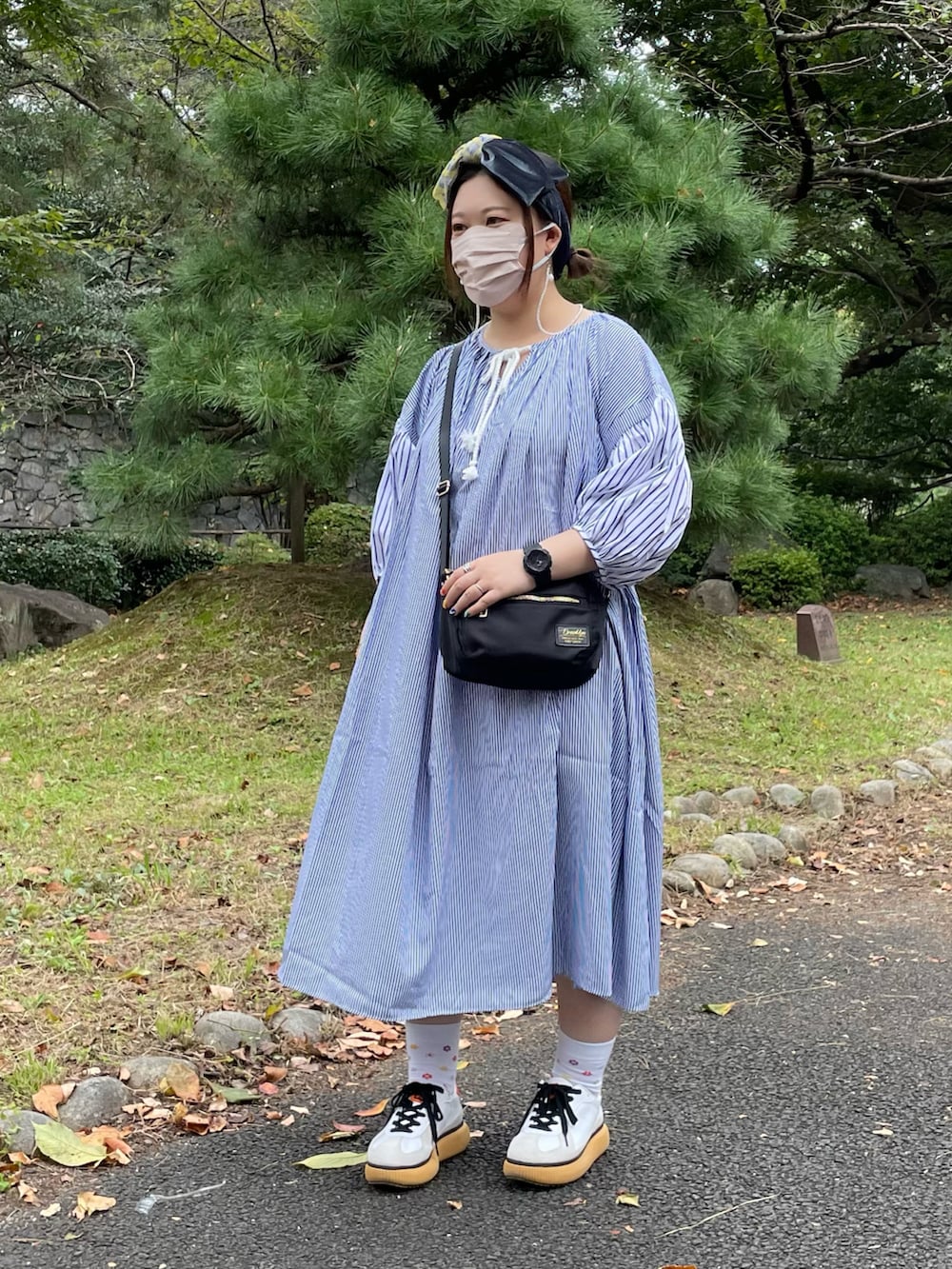 ホワイト系のスニーカー、ブルー系のヘアバンドを着用したレディースの秋コーディネートの2枚目の写真