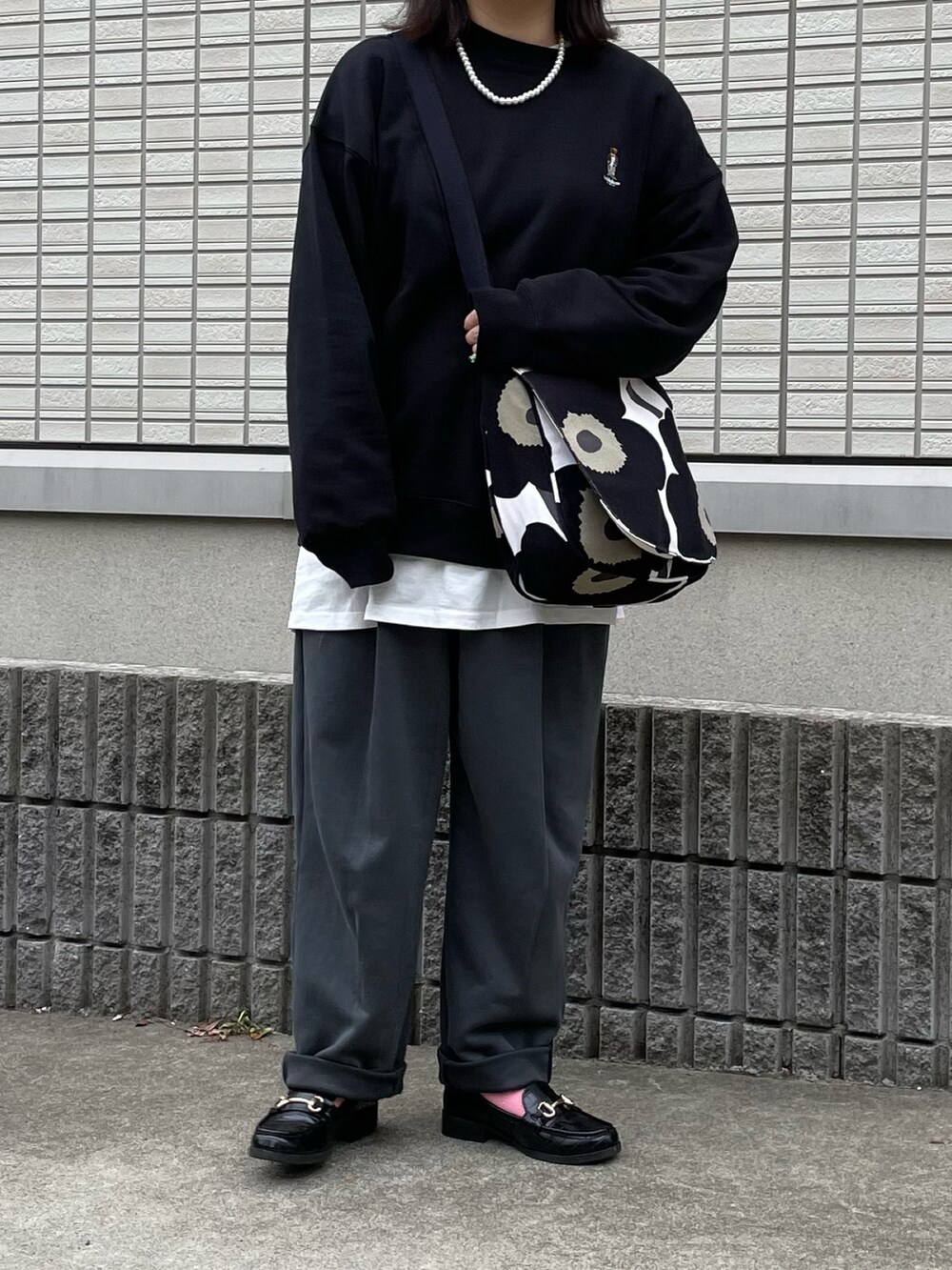 ブラック系のスウェット、ブラック系のローファー、ブラック系のショルダーバッグを着用したレディースの春コーディネートの2枚目の写真