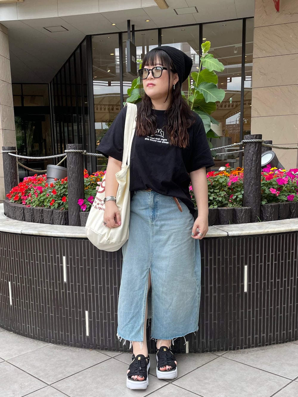 ブラック系のサンダル、ベージュ系のトートバッグ、ブラック系のTシャツ/カットソーを着用したレディースの夏コーディネートの2枚目の写真