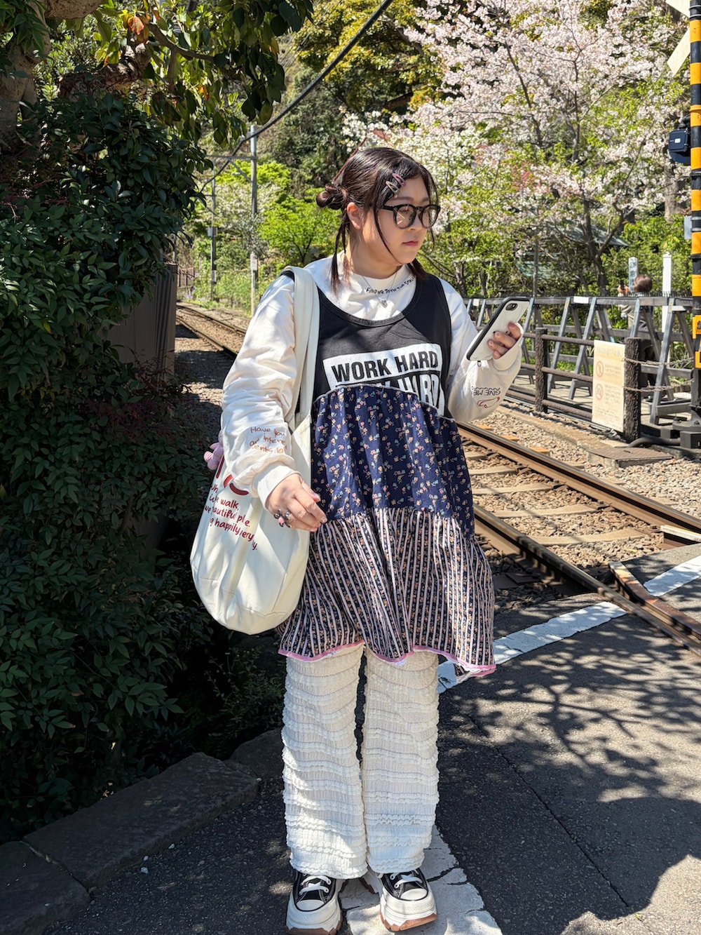 ホワイト系のその他パンツ、ホワイト系のTシャツ/カットソー、ブラック系のスニーカーを着用したレディースの春コーディネートの2枚目の写真