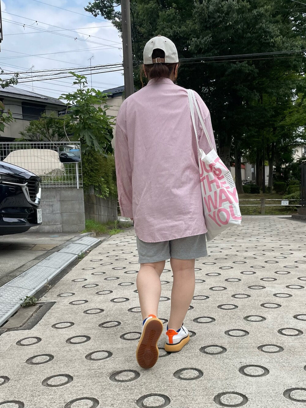 レッド系のシャツ/ブラウス、ホワイト系のトートバッグ、ホワイト系のスニーカーを着用したレディースの夏コーディネートの4枚目の写真
