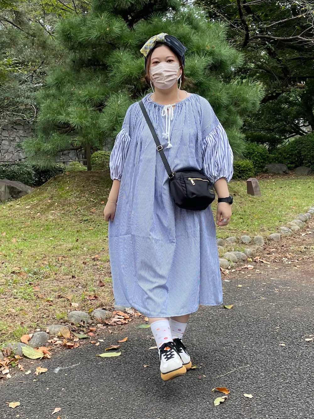 ホワイト系のスニーカー、ブルー系のヘアバンドを着用したレディースの秋コーディネートの3枚目の写真