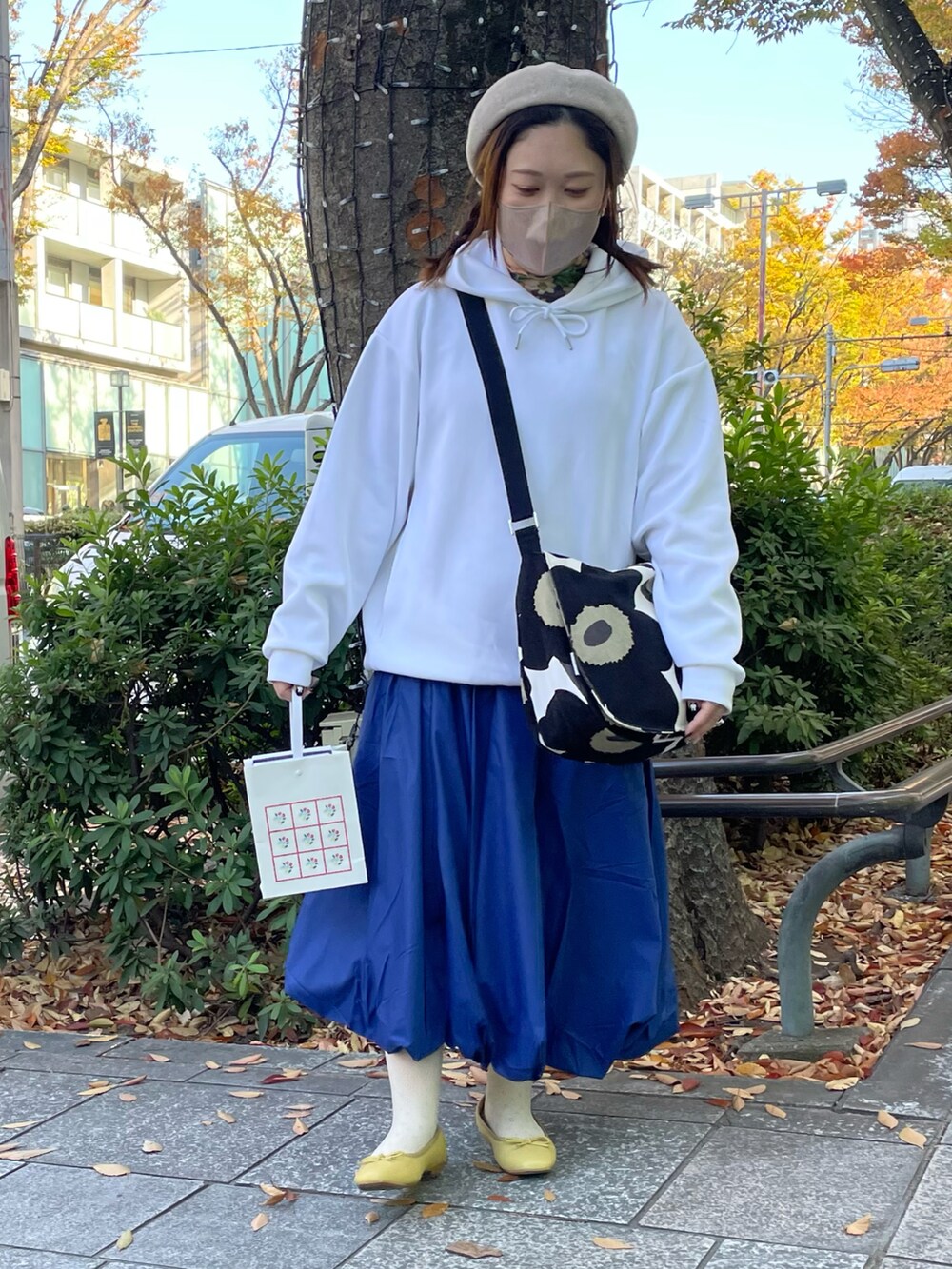 ブルー系のスカート、イエロー系のバレエシューズを着用したレディースの秋コーディネートの3枚目の写真