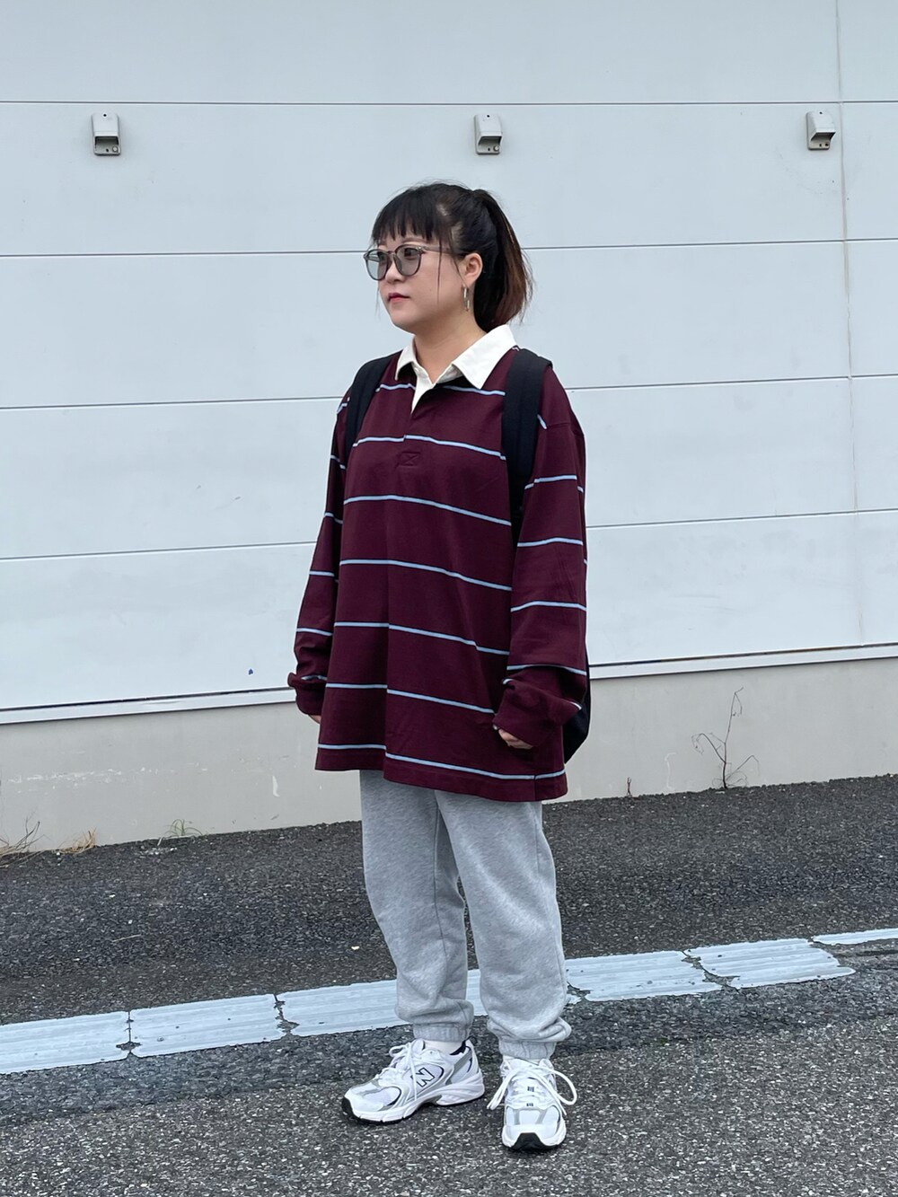 グレー系のパンツ、ブラック系のバックパック/リュックを着用したレディースの秋コーディネートの2枚目の写真