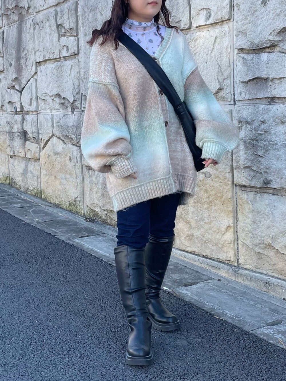 グリーン系のカーディガン/ボレロ、ブラック系のブーツ、ブラック系のショルダーバッグを着用したレディースの冬コーディネートの2枚目の写真