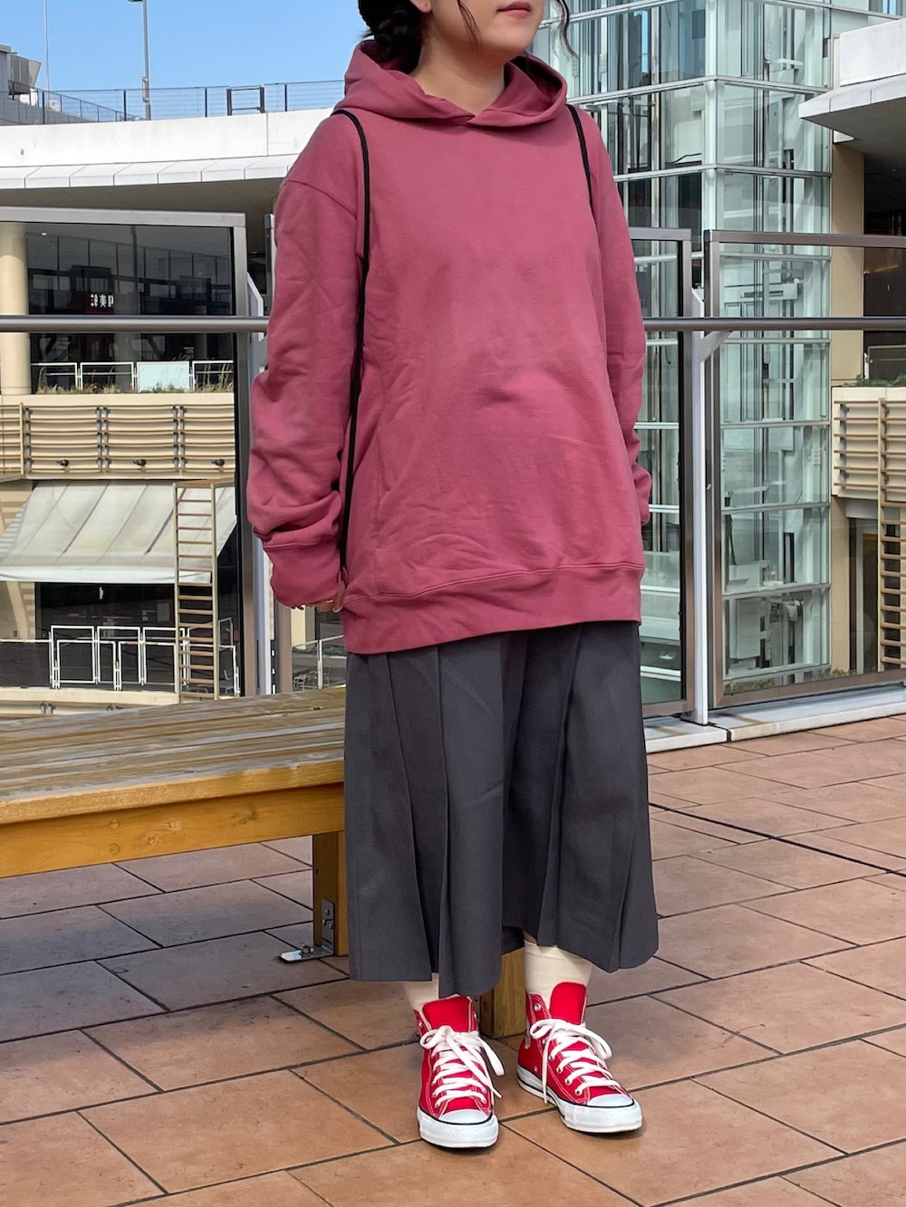 レッド系のスニーカー、ブラック系のバックパック/リュック、ブラック系のハンチング/ベレー帽を着用したレディースの春コーディネートの2枚目の写真