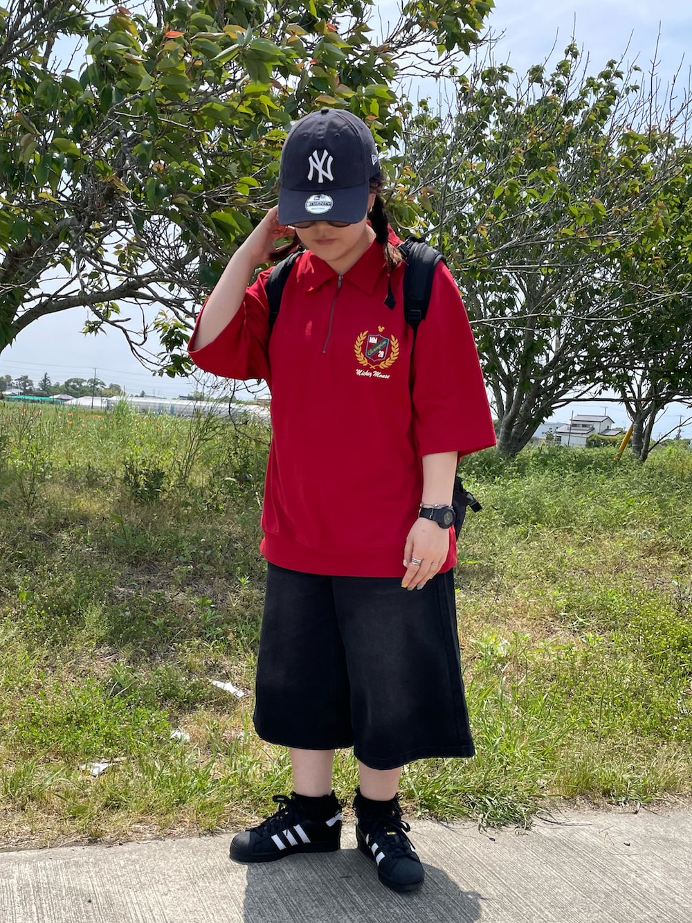 ブラック系のバックパック/リュック、ブラック系のパンツ、ブラック系のスニーカーを着用したレディースの春コーディネートの2枚目の写真