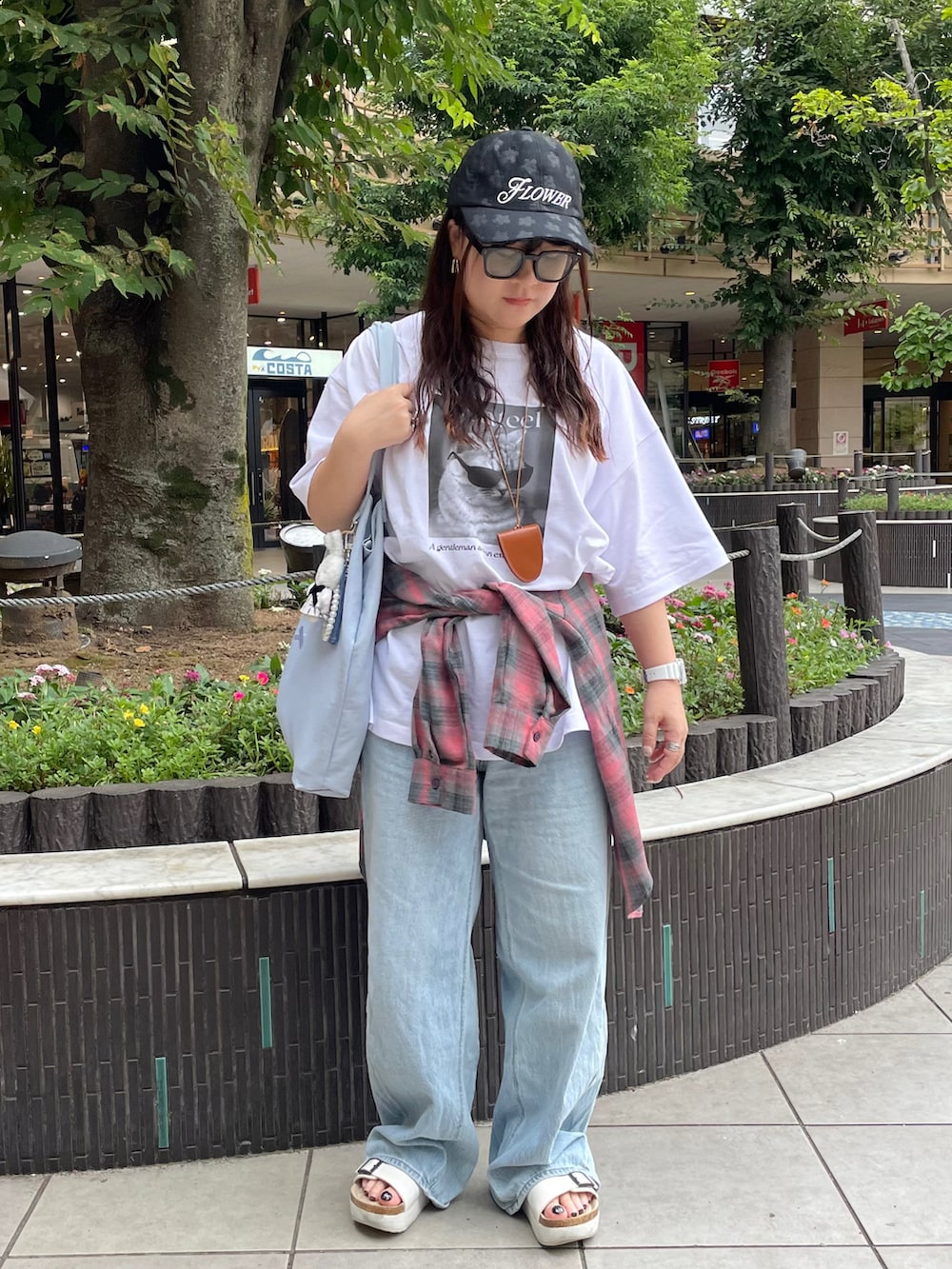 ホワイト系のTシャツ/カットソー、ブルー系のトートバッグ、ブラウン系のサングラスを着用したレディースの夏コーディネートの2枚目の写真