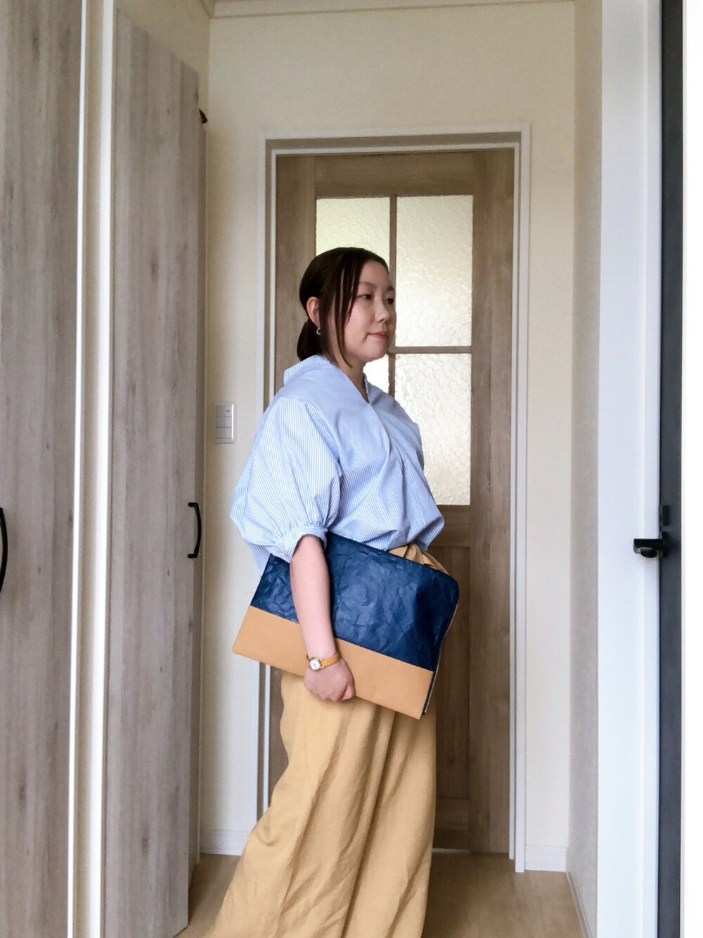 ブルー系のシャツ/ブラウス、ブルー系のクラッチバッグ、イエロー系のその他パンツを着用したレディースの夏コーディネートの2枚目の写真