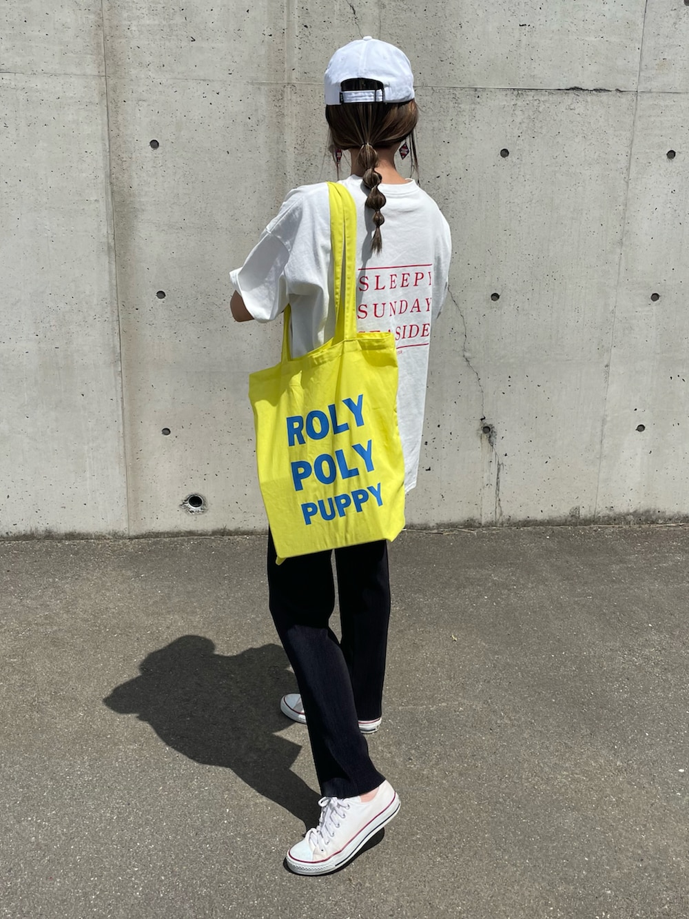 レッド系のTシャツ/カットソー、イエロー系のトートバッグ、ホワイト系のスニーカーを着用したレディースの春コーディネートの2枚目の写真
