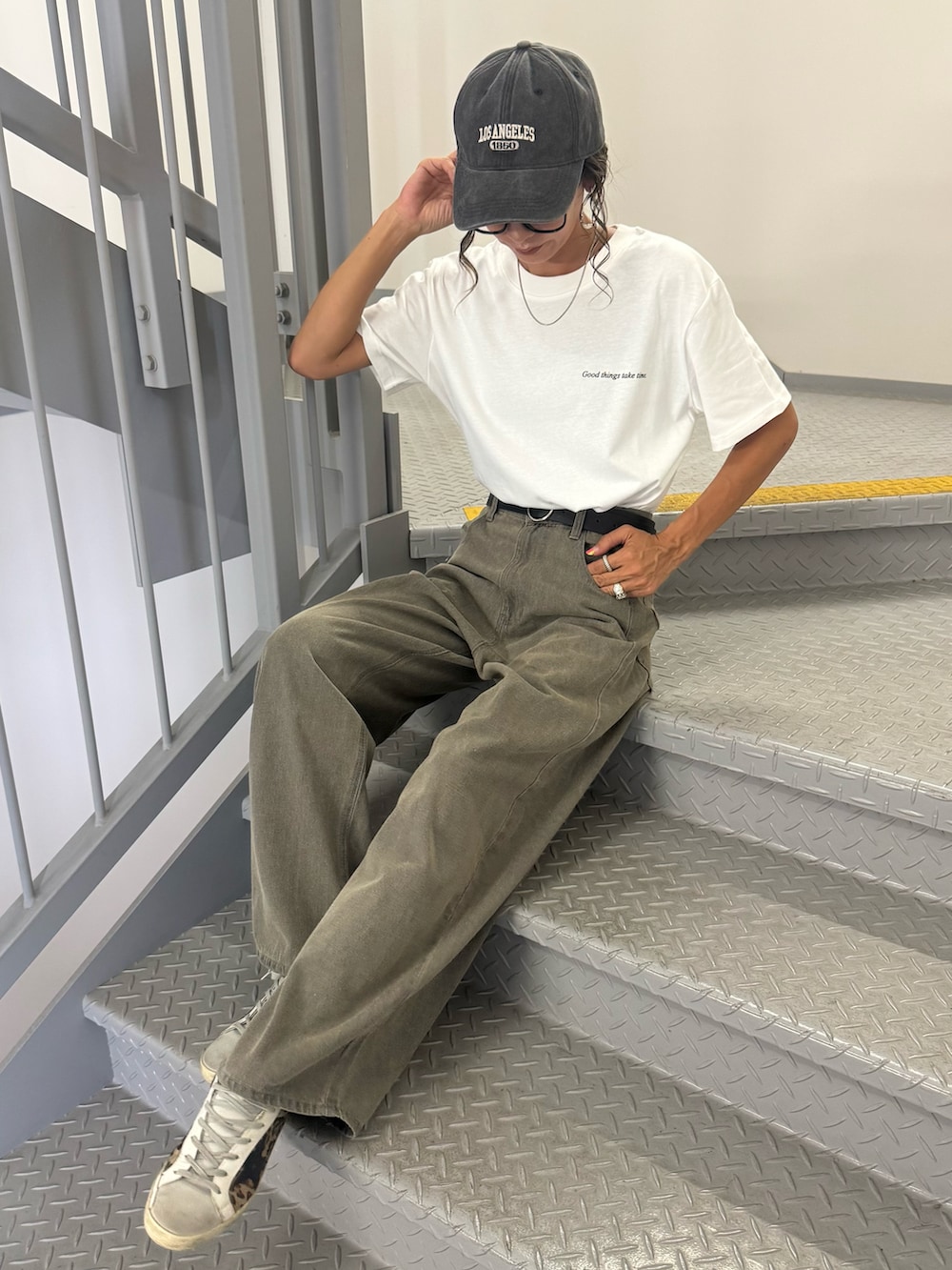 ブラック系のTシャツ/カットソー、ベージュ系のデニムパンツ、ベージュ系のスニーカーを着用したレディースの夏コーディネートの2枚目の写真