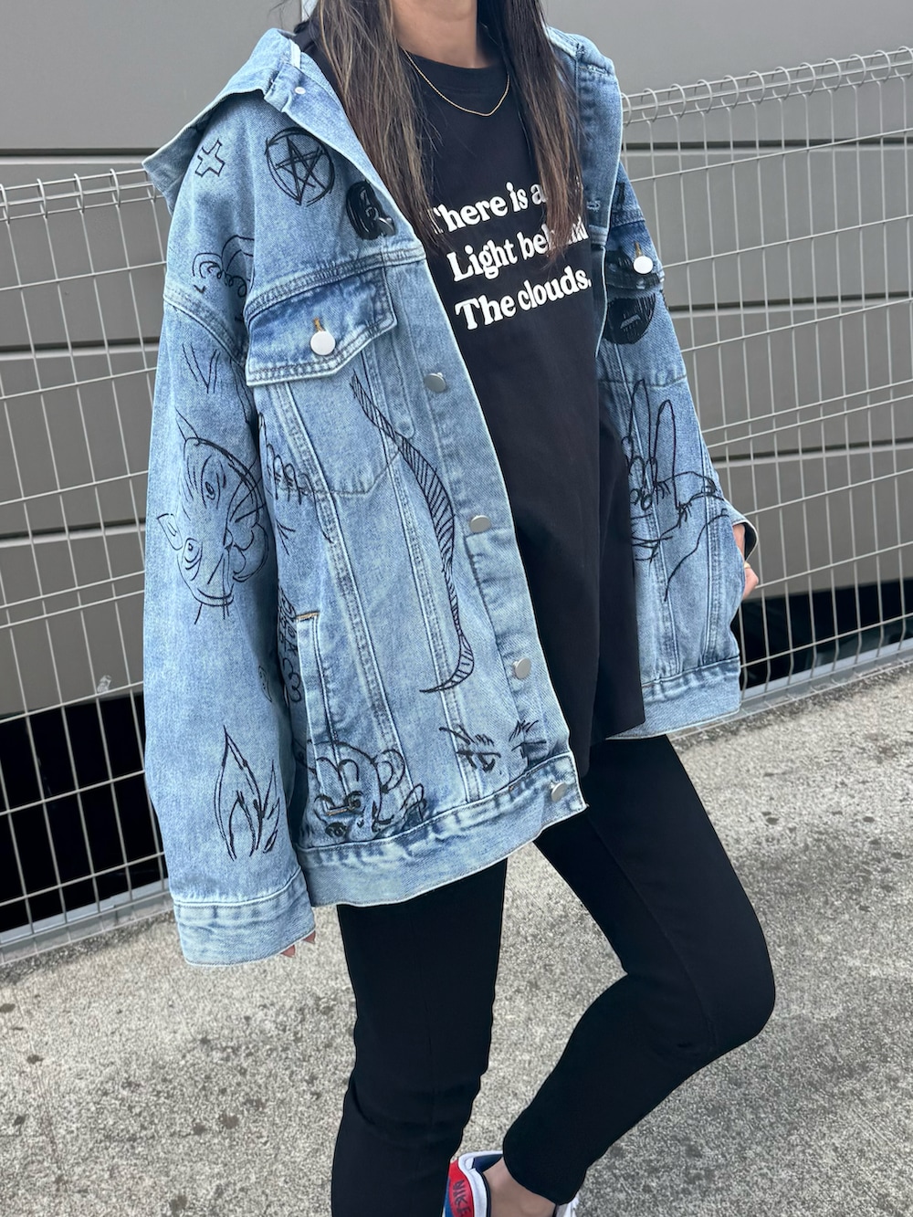 ブラック系のTシャツ/カットソー、ブルー系のデニムジャケット、ブラック系のデニムパンツを着用したレディースの春コーディネートの5枚目の写真