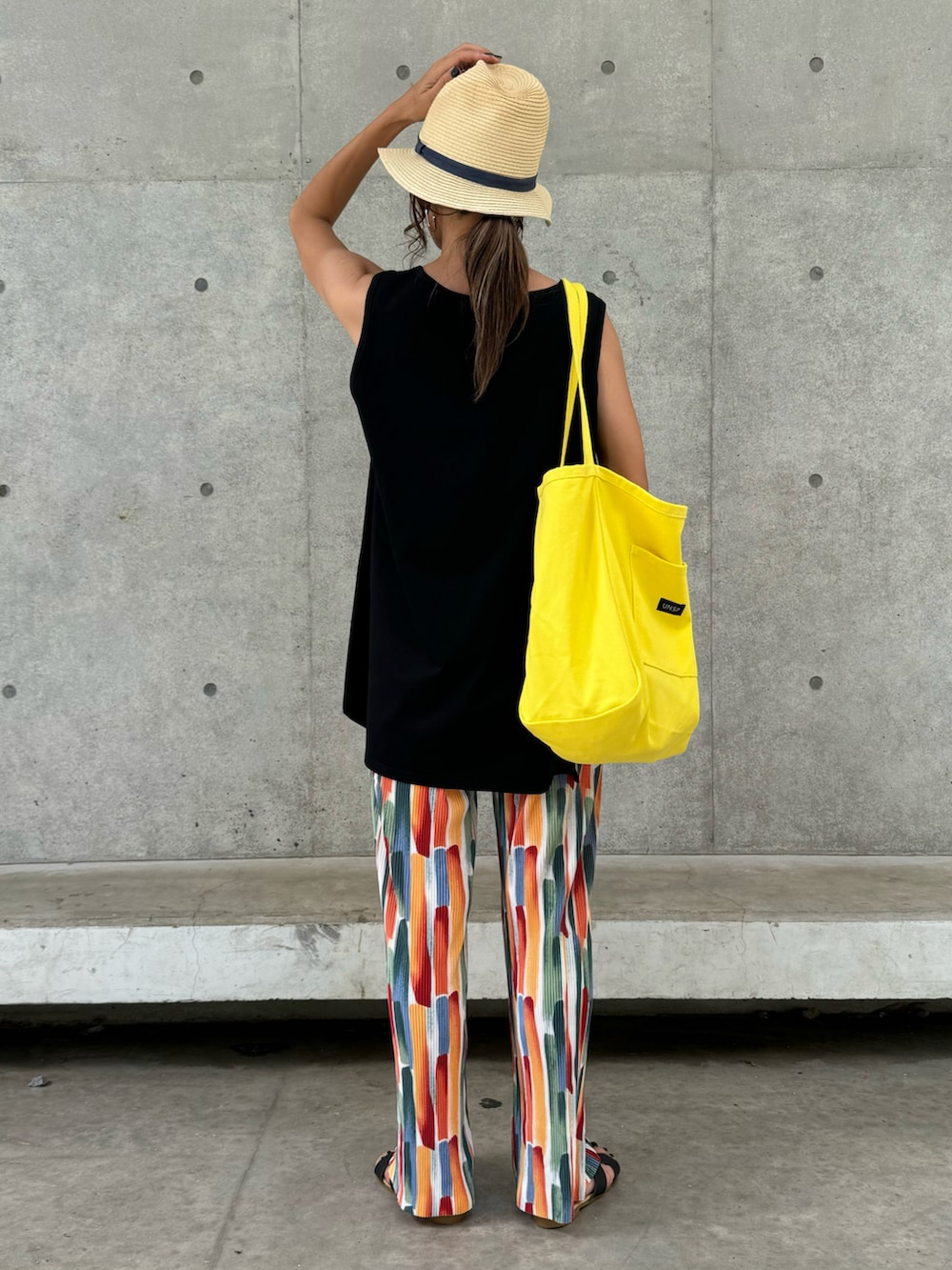 ブラック系のタンクトップ、その他のその他パンツ、イエロー系のトートバッグを着用したレディースの夏コーディネートの3枚目の写真