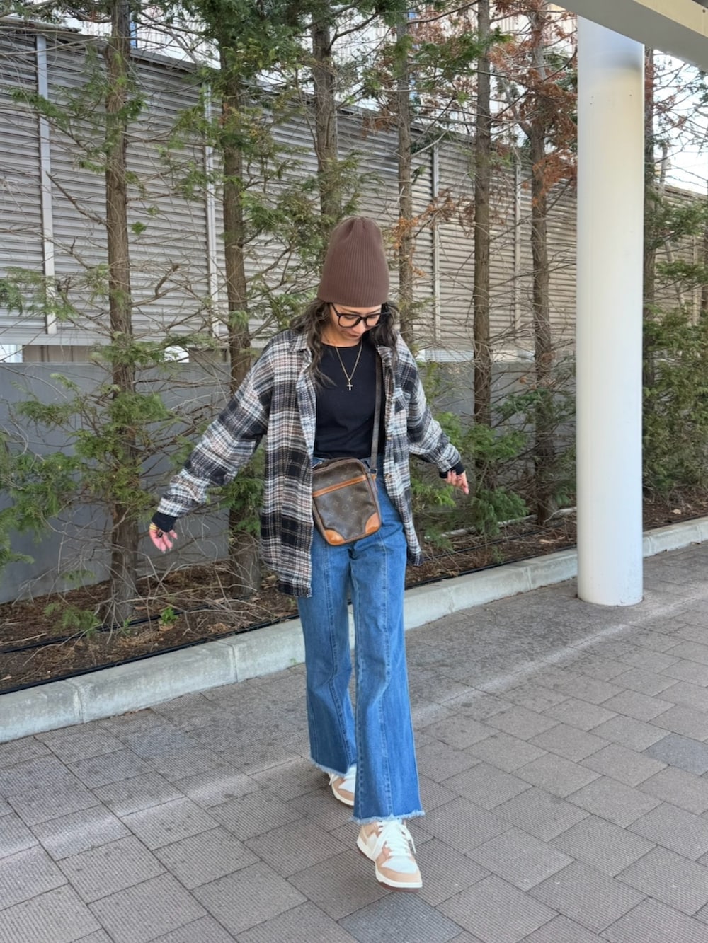 ブラック系のシャツ/ブラウス、ブラック系のTシャツ/カットソー、ブルー系のデニムパンツを着用したレディースの春コーディネートの3枚目の写真