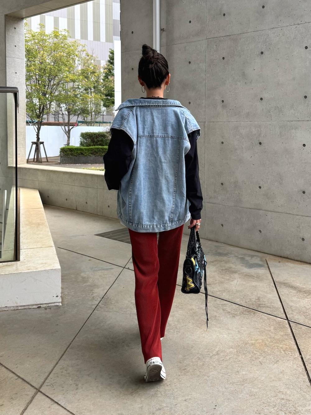 ブルー系のベスト、レッド系のその他パンツ、ホワイト系のスニーカーを着用したレディースの春コーディネートの2枚目の写真