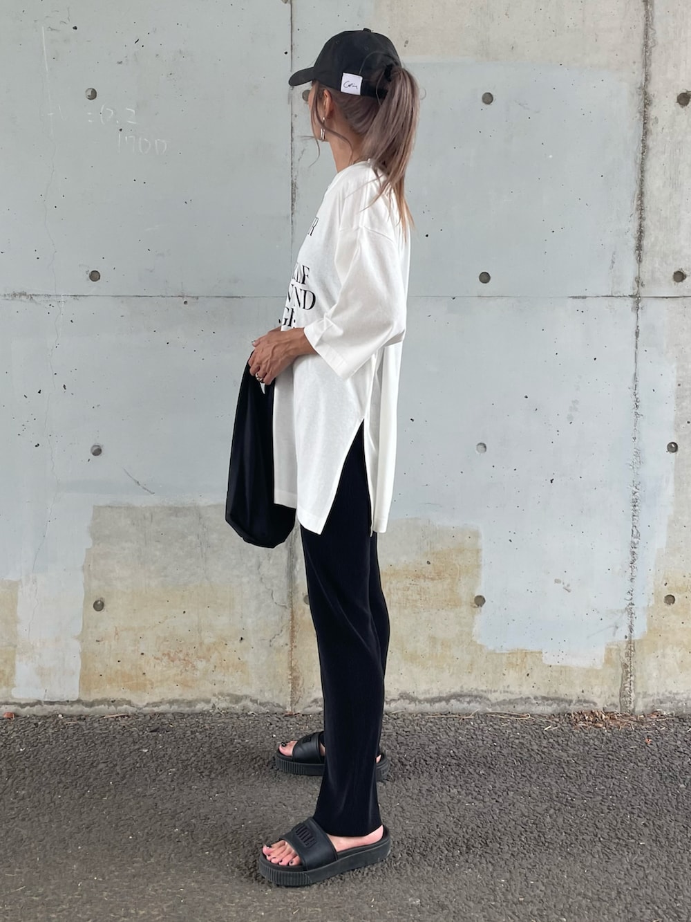 ホワイト系のTシャツ/カットソー、ブラック系のサンダル、その他のエコバッグ/サブバッグを着用したレディースの夏コーディネートの5枚目の写真