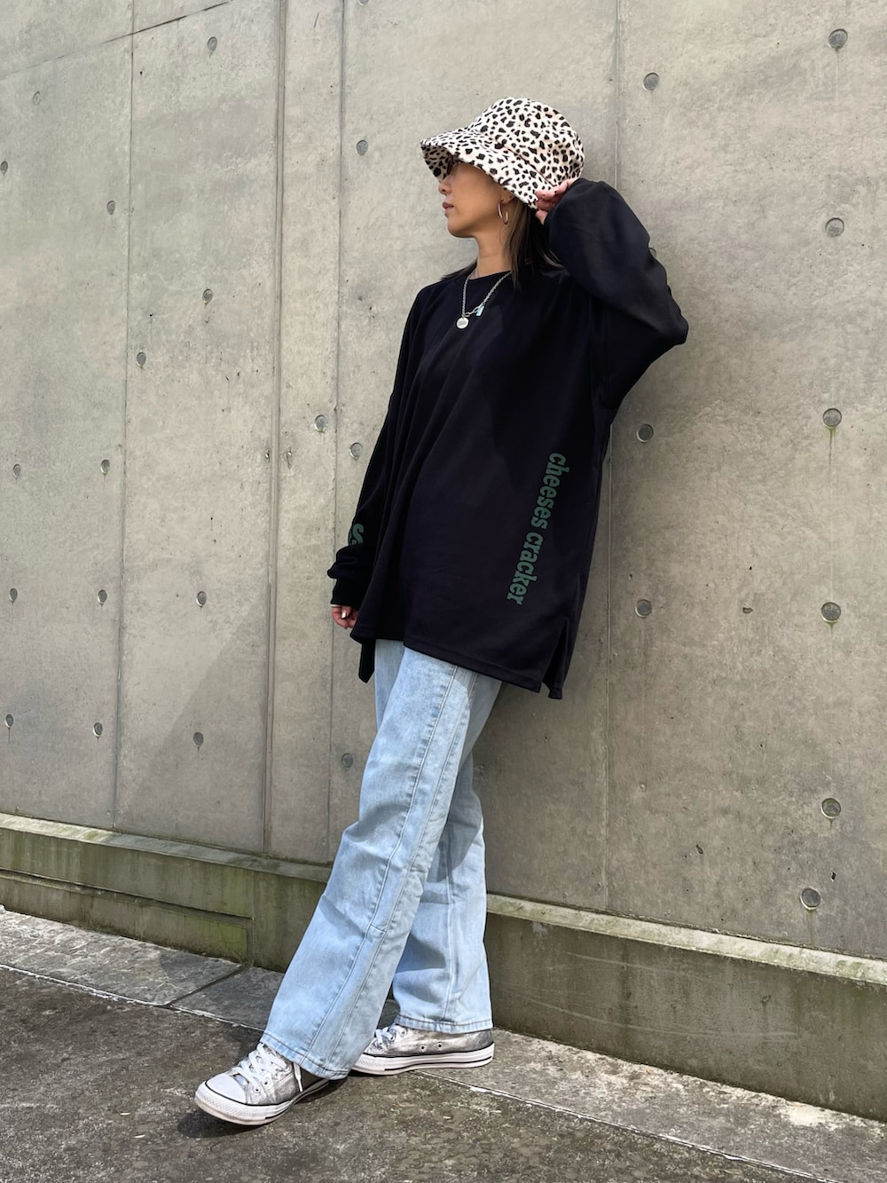 ブラック系のスウェット、ブルー系のデニムパンツ、シルバー系のスニーカーを着用したレディースの秋コーディネートの2枚目の写真