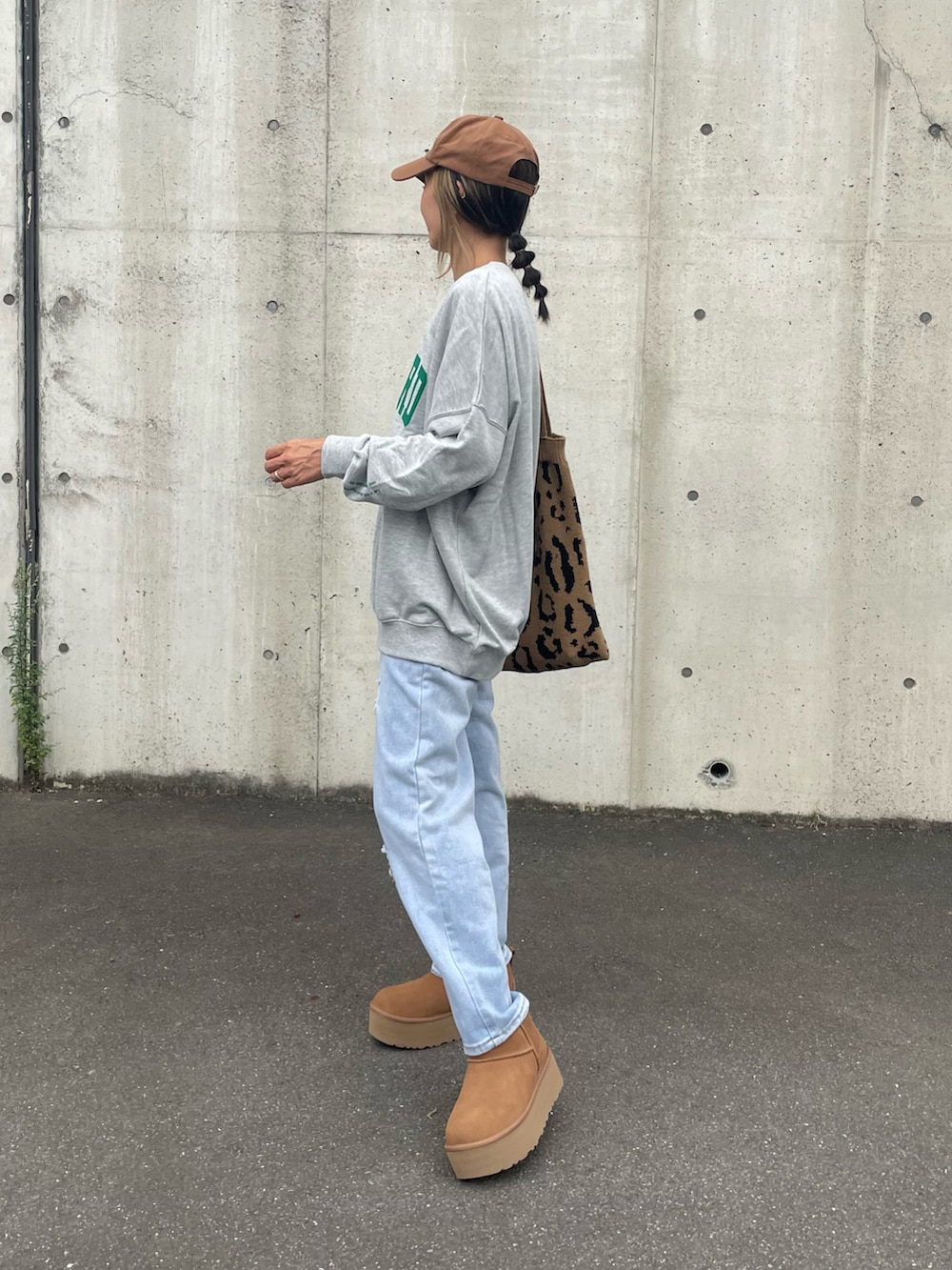 ブルー系のデニムパンツ、その他のトートバッグ、ブラウン系のブーツを着用したレディースの秋コーディネートの3枚目の写真