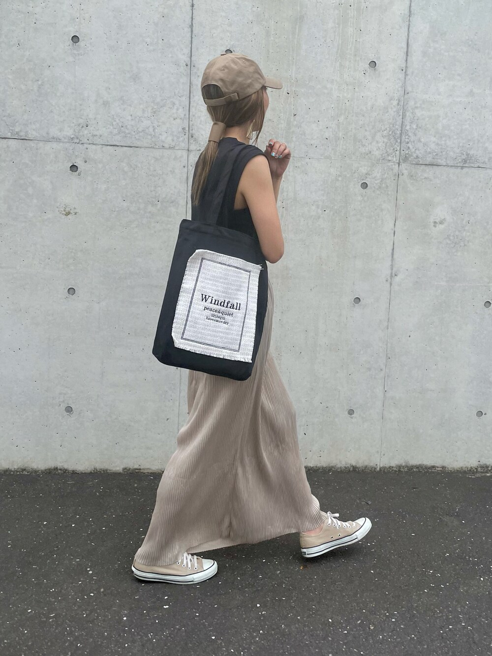 ブラック系のTシャツ/カットソー、ベージュ系のスカート、ブラック系のトートバッグを着用したレディースの夏コーディネートの3枚目の写真