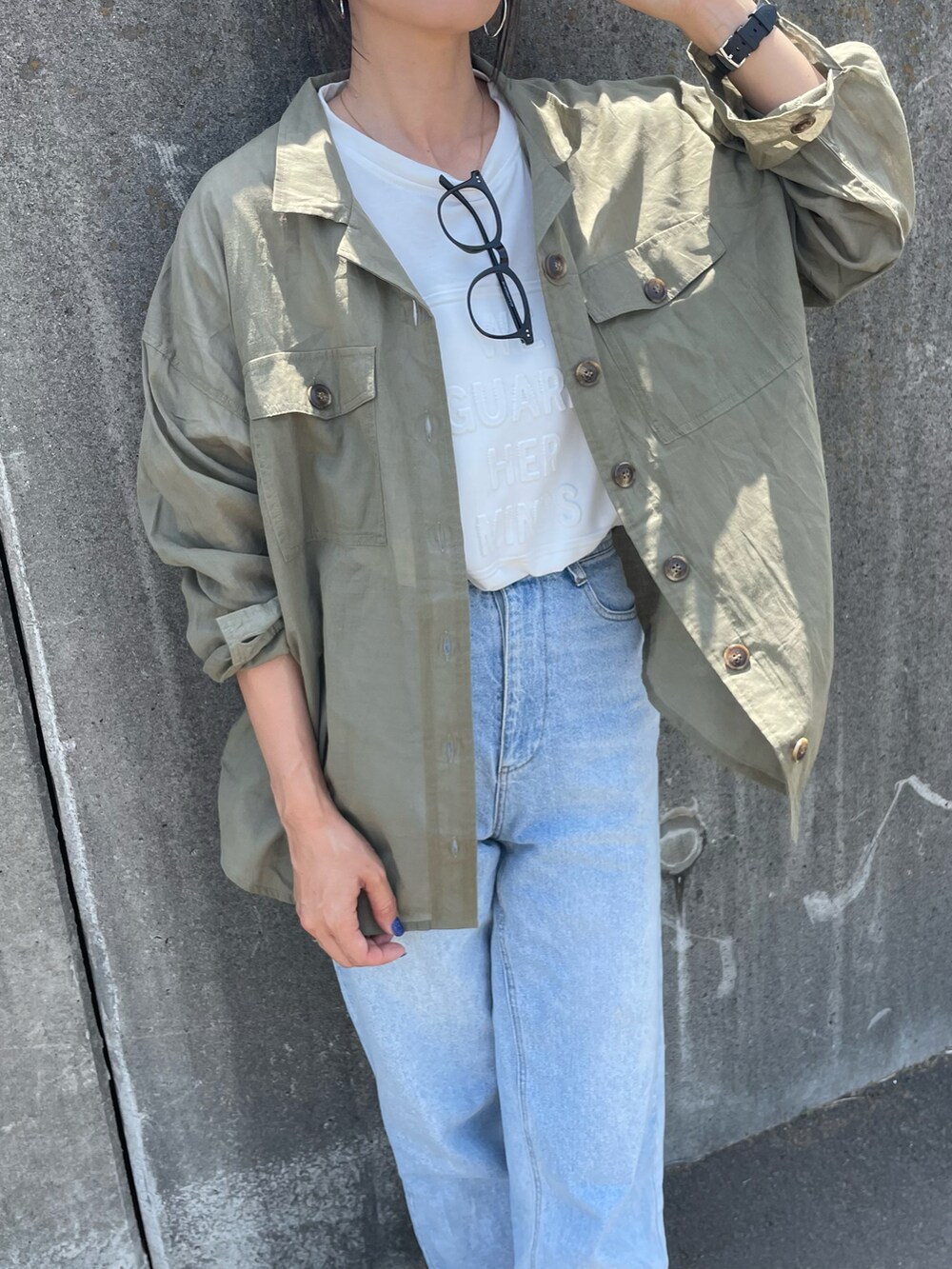 ホワイト系のTシャツ/カットソー、ブルー系のデニムパンツ、ホワイト系のサンダルを着用したレディースの春コーディネートの2枚目の写真