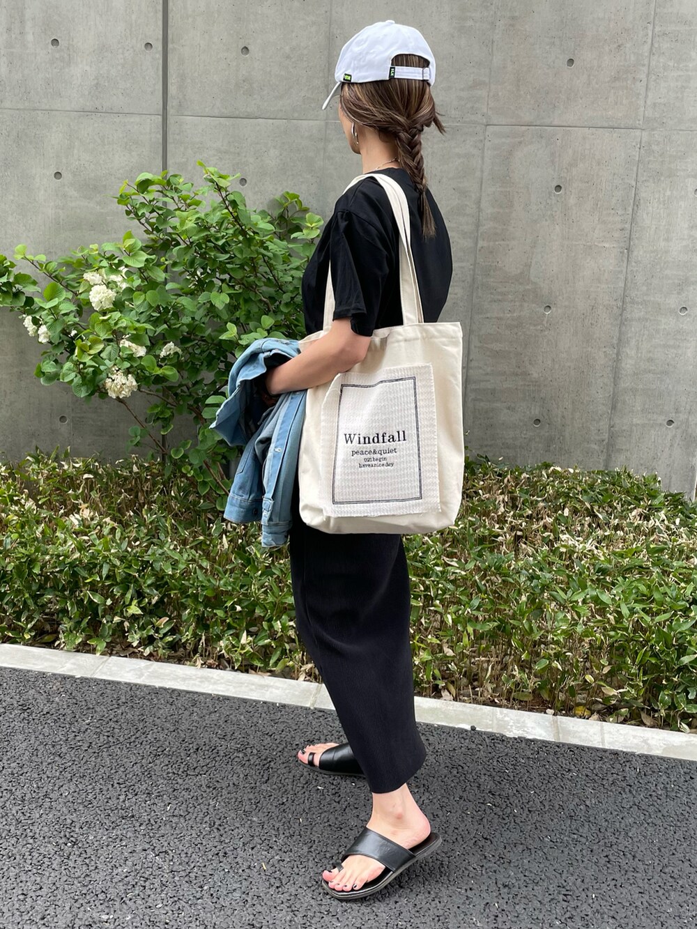 ブラック系のTシャツ/カットソー、ブラック系のスカート、ホワイト系のトートバッグを着用したレディースの夏コーディネートの2枚目の写真