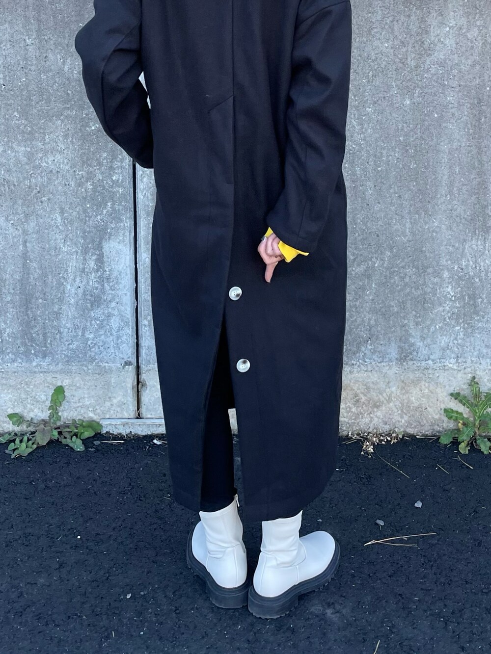 イエロー系のスウェット、ブラック系のノーカラーコート、ブラック系のその他パンツを着用したレディースの秋コーディネートの4枚目の写真