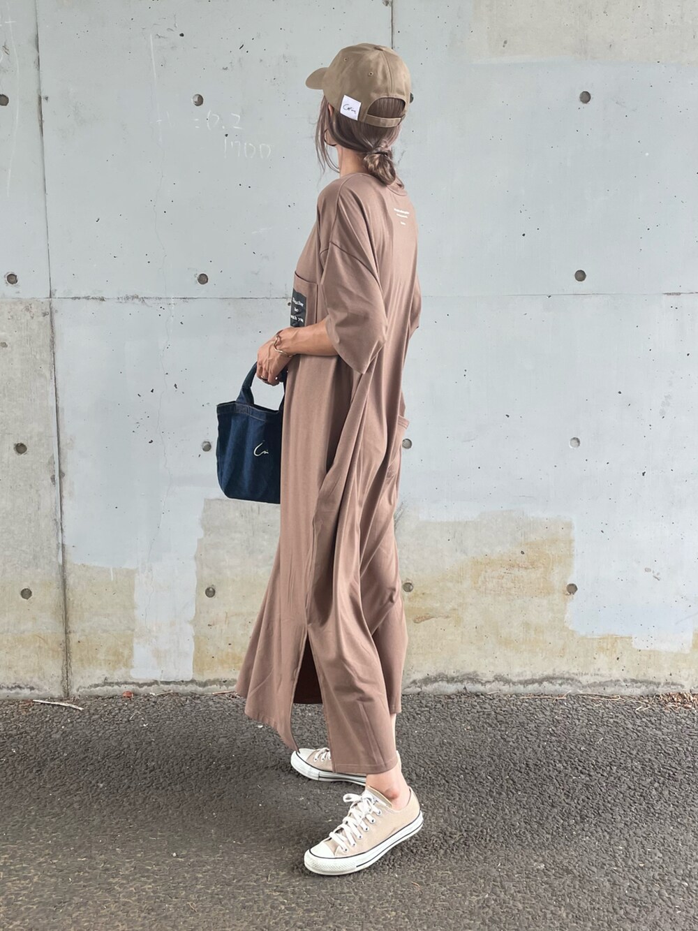 ブラウン系のワンピース、ブルー系のトートバッグ、ベージュ系のスニーカーを着用したレディースの夏コーディネートの3枚目の写真