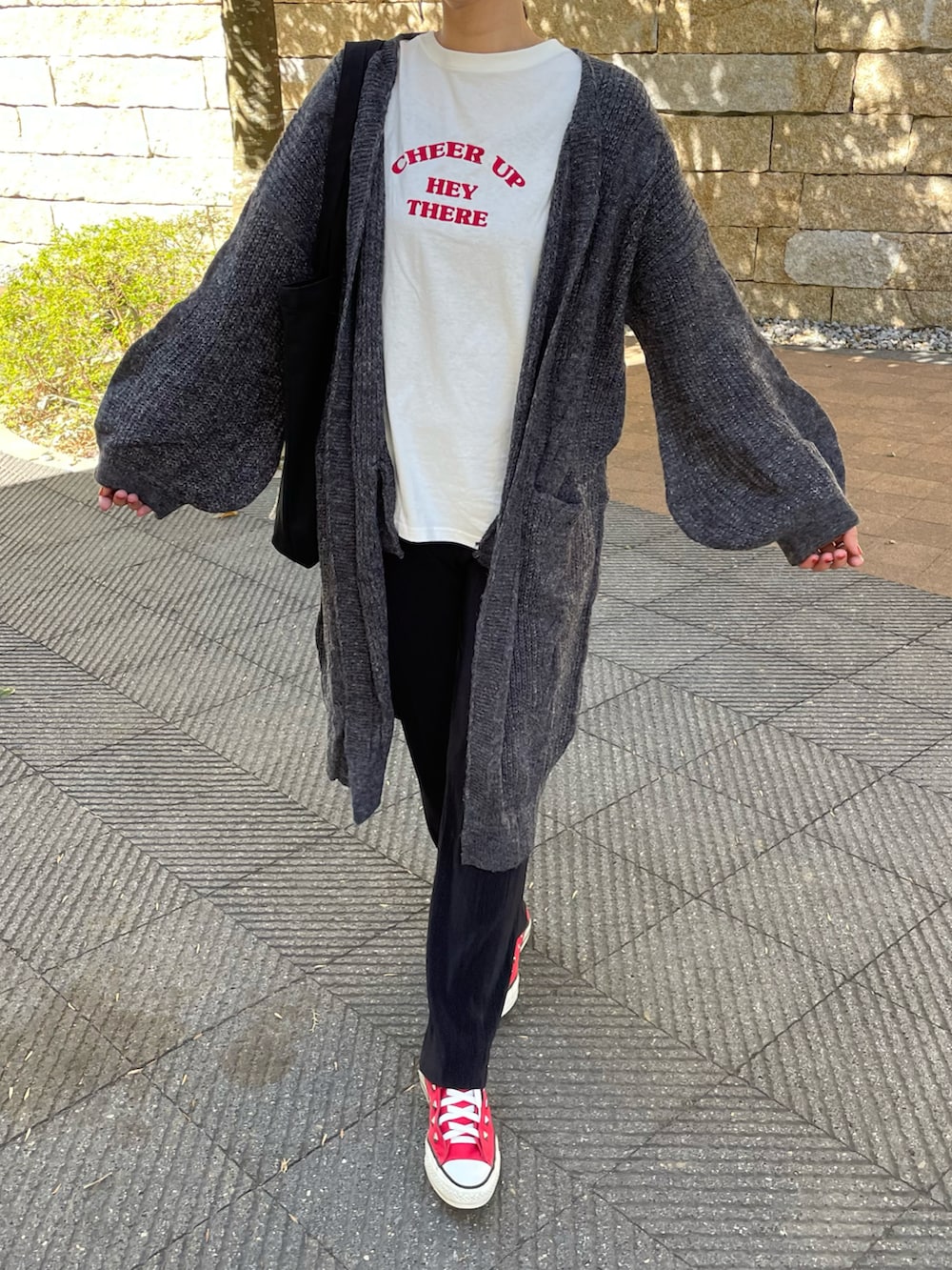 その他のニット/セーター、レッド系のTシャツ/カットソー、ブラック系のトートバッグを着用したレディースの冬コーディネートの3枚目の写真