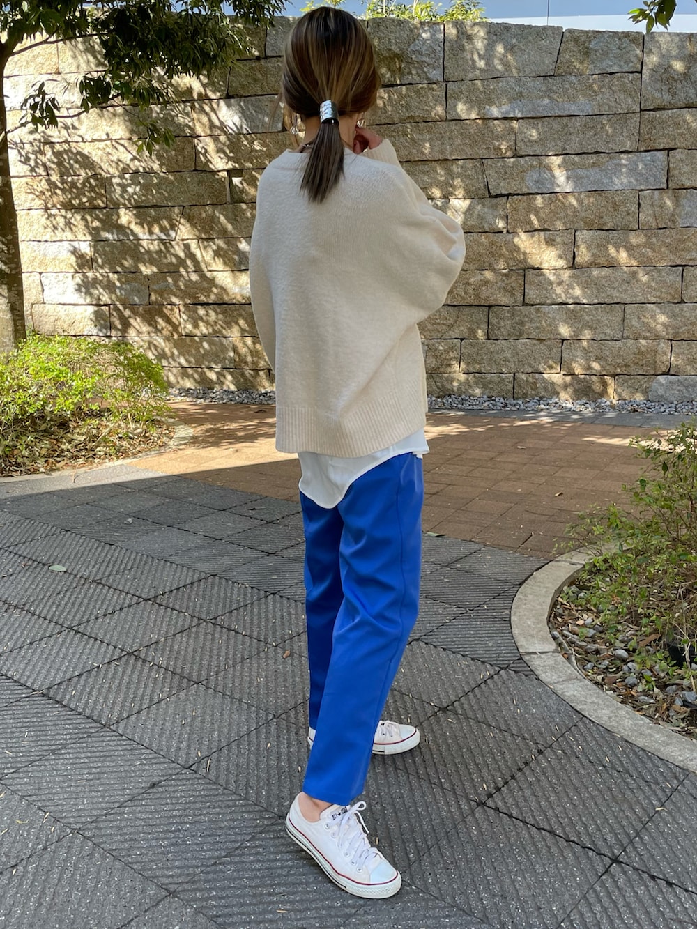 ホワイト系のニット/セーター、ホワイト系のその他トップス、ホワイト系のスニーカーを着用したレディースの春コーディネートの2枚目の写真