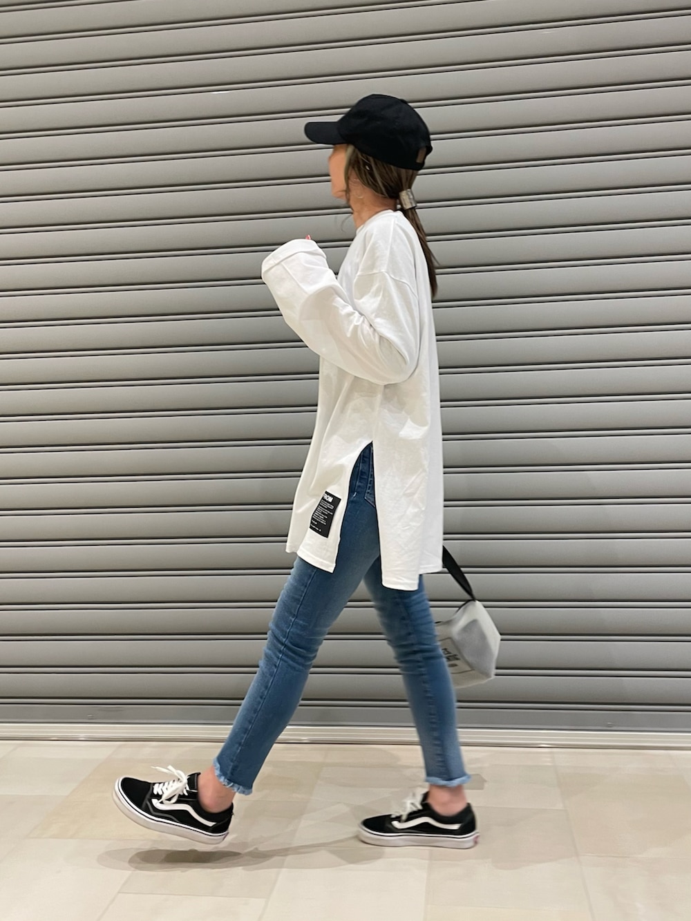 ホワイト系のTシャツ/カットソー、その他のショルダーバッグ、ブラック系のスニーカーを着用したレディースの冬コーディネートの2枚目の写真