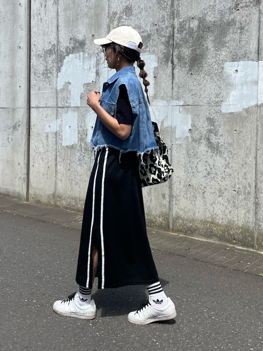 ブラック系のTシャツ/カットソー、ブルー系のベスト、ブラック系のスカートを着用したレディースの春コーディネートの2枚目の写真