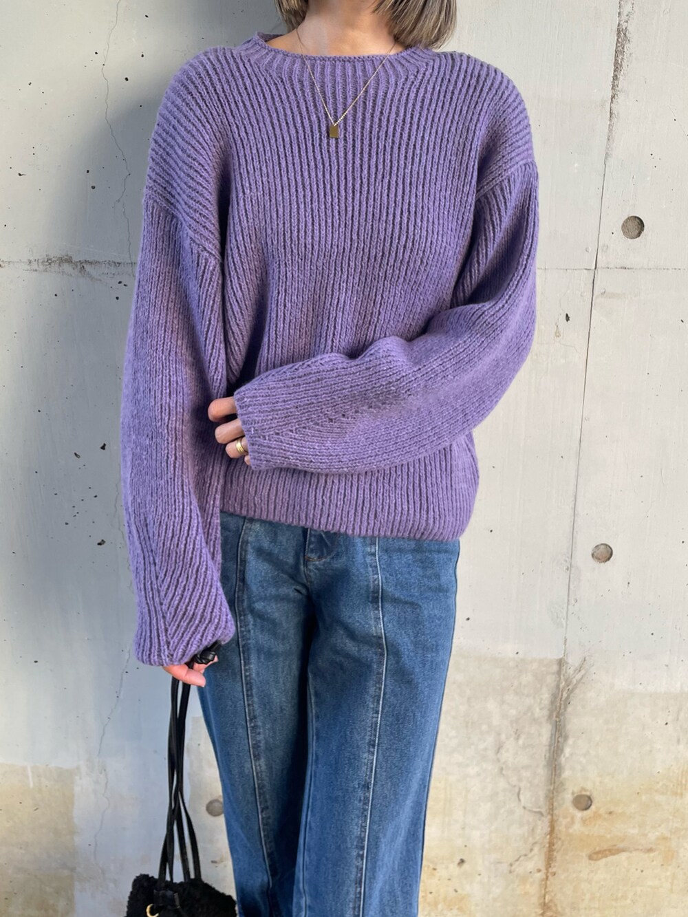 ブルー系のニット/セーター、ブラック系のダウンベスト、ブルー系のデニムパンツを着用したレディースの冬コーディネートの5枚目の写真