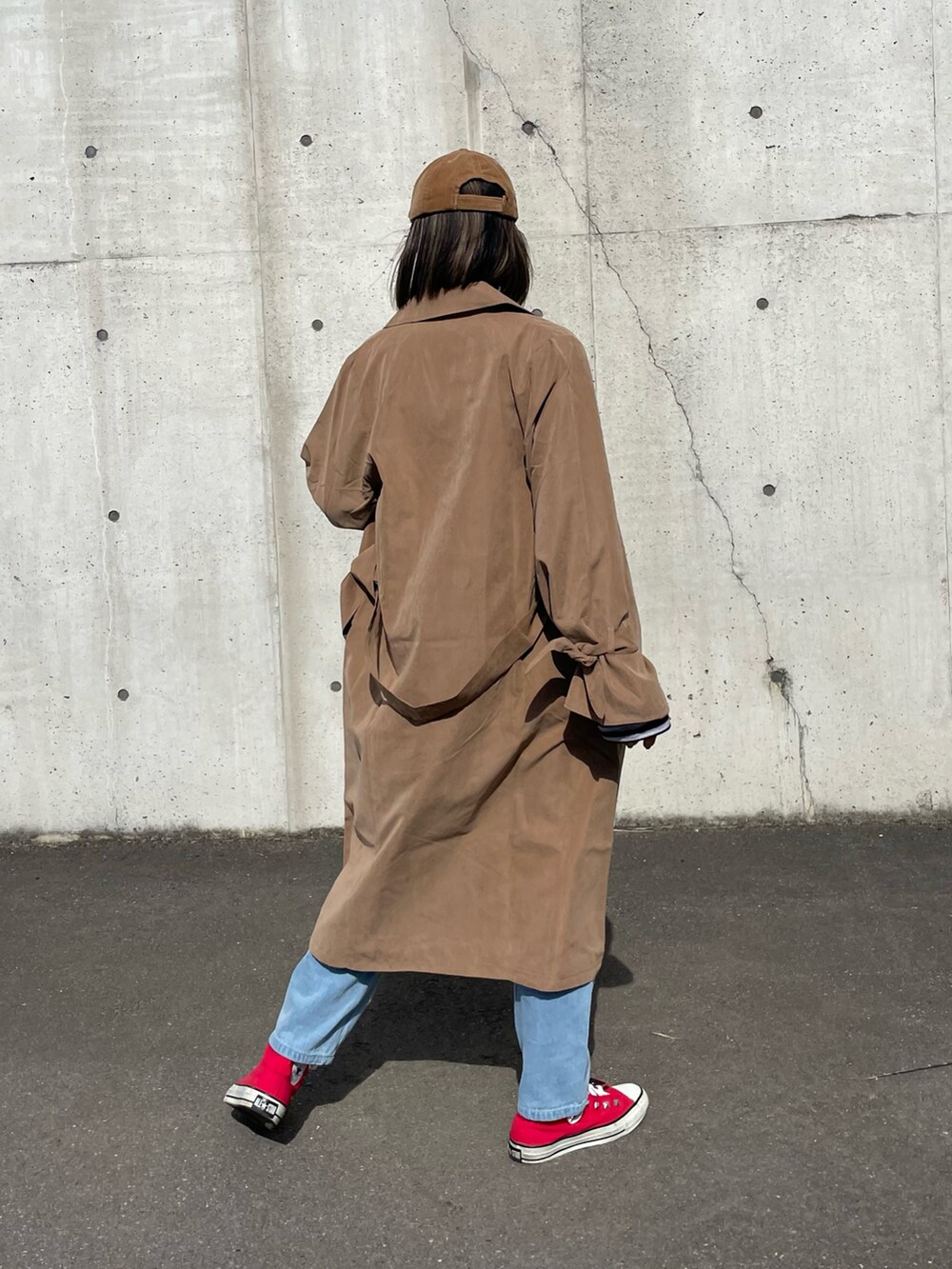 ブラック系のTシャツ/カットソー、ブラウン系のトレンチコート、ブルー系のデニムパンツを着用したレディースの冬コーディネートの4枚目の写真