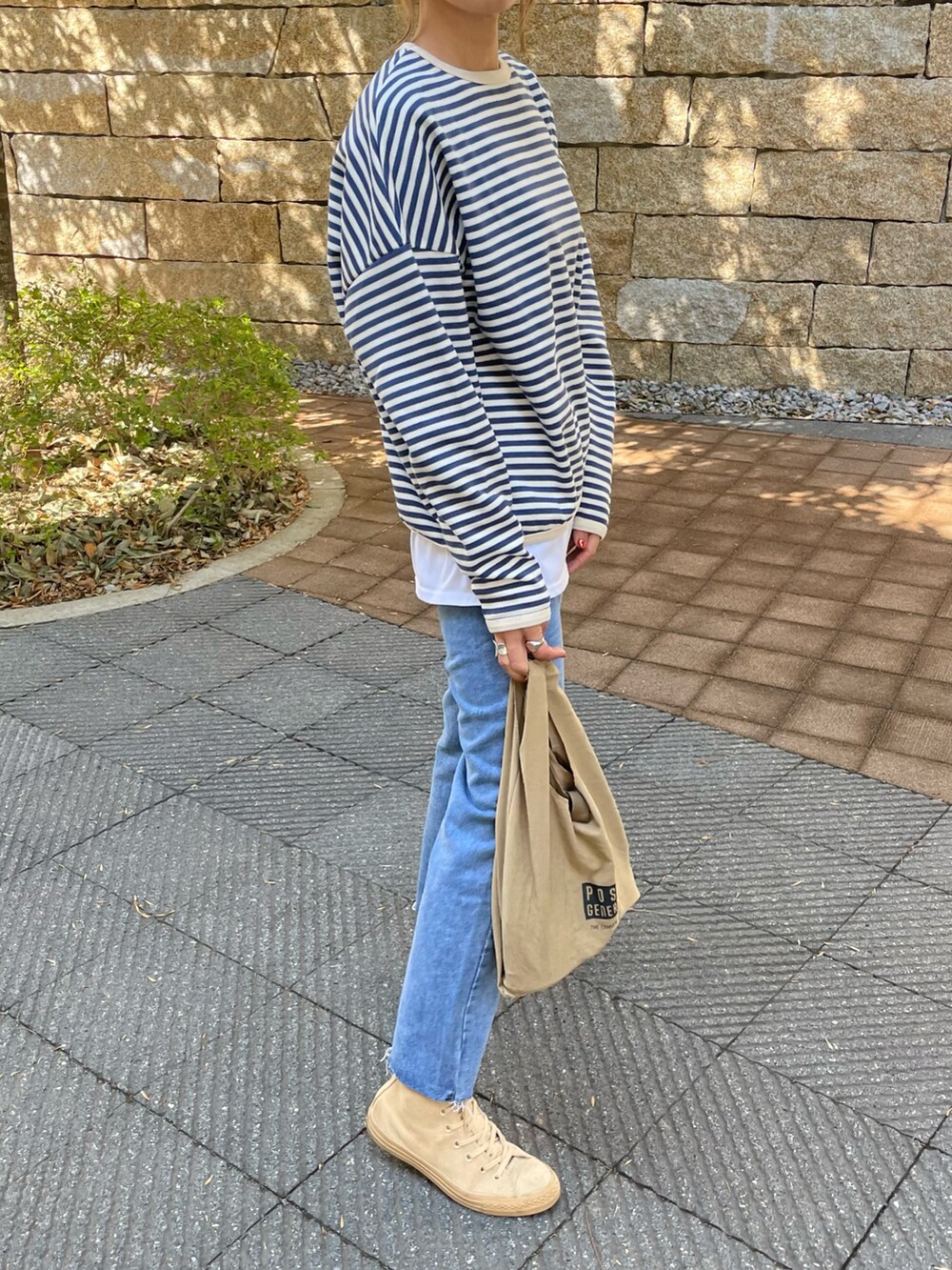 ブルー系のTシャツ/カットソー、ブルー系のデニムパンツ、その他のエコバッグ/サブバッグを着用したレディースの春コーディネートの3枚目の写真