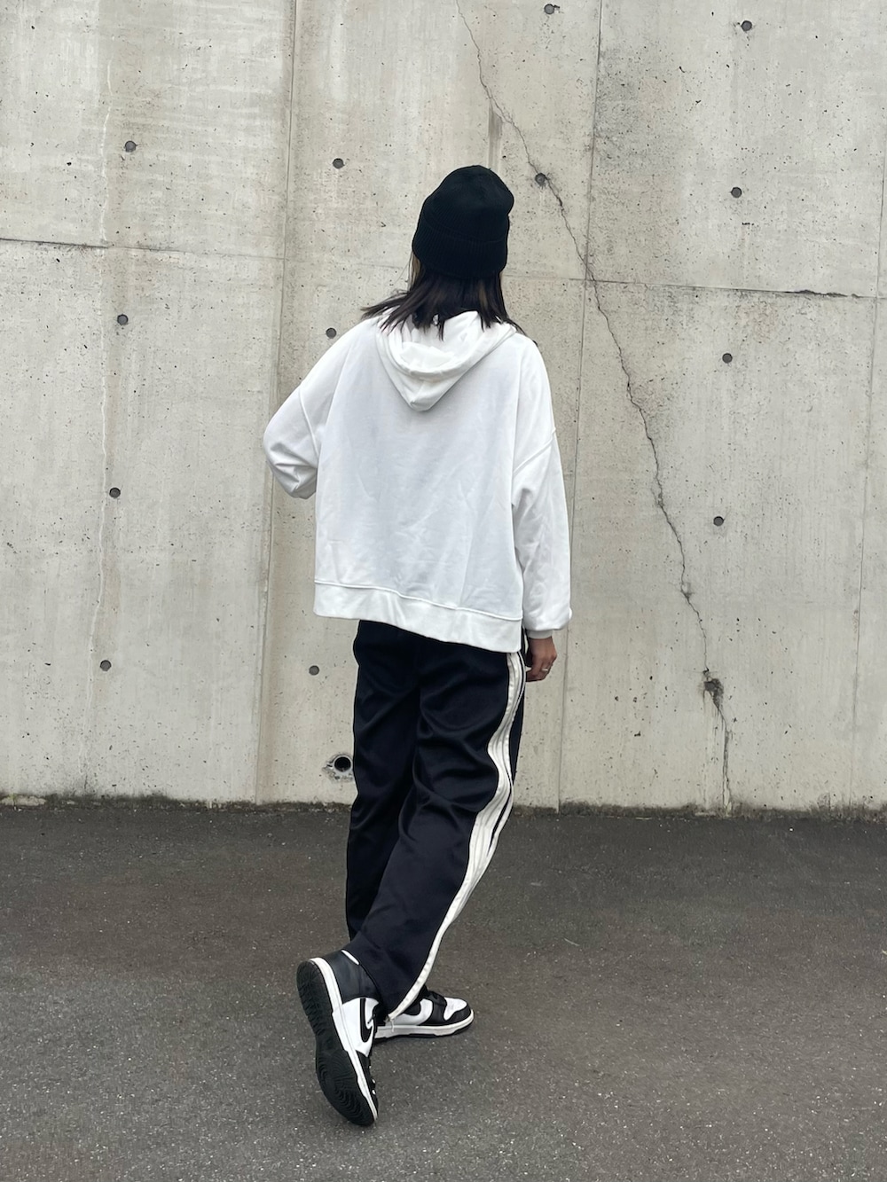 ブラック系のその他パンツ、ホワイト系のスニーカー、その他のバングル/リストバンドを着用したレディースの秋コーディネートの2枚目の写真