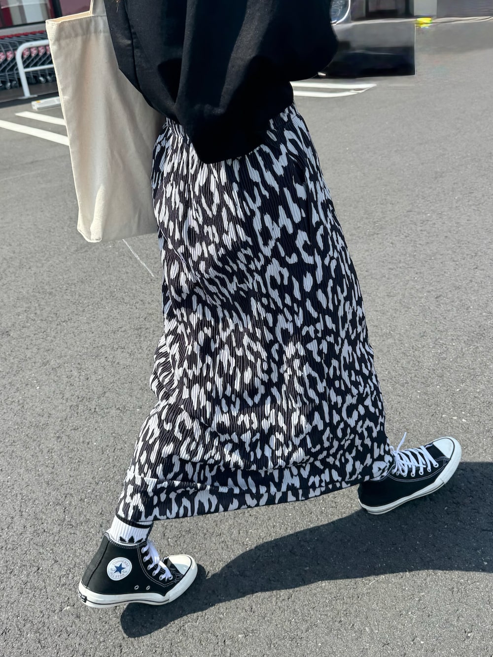 ブラック系のスニーカー、ブラック系のTシャツ/カットソー、ホワイト系のトートバッグを着用したレディースの夏コーディネートの5枚目の写真