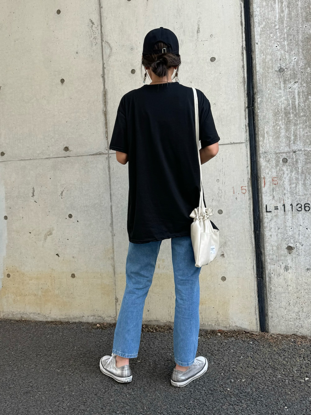 ブラック系のTシャツ/カットソー、ブルー系のデニムパンツ、ホワイト系のショルダーバッグを着用したレディースの春コーディネートの3枚目の写真