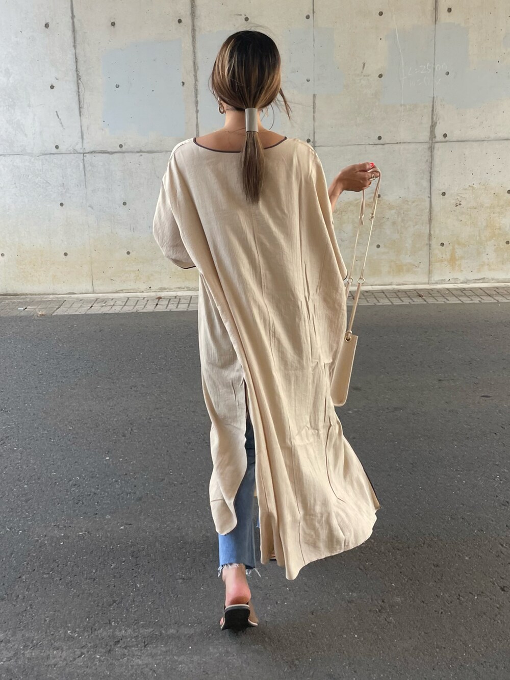 ベージュ系のワンピース、ブルー系のデニムパンツ、ブラウン系のサンダルを着用したレディースの夏コーディネートの4枚目の写真