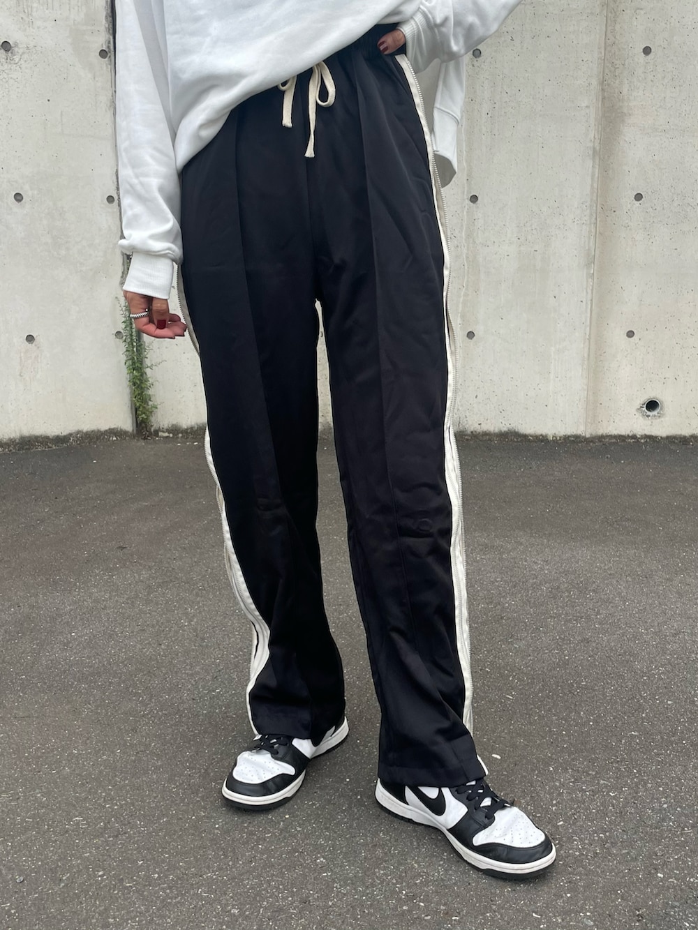 ブラック系のその他パンツ、ホワイト系のスニーカー、その他のバングル/リストバンドを着用したレディースの秋コーディネートの4枚目の写真