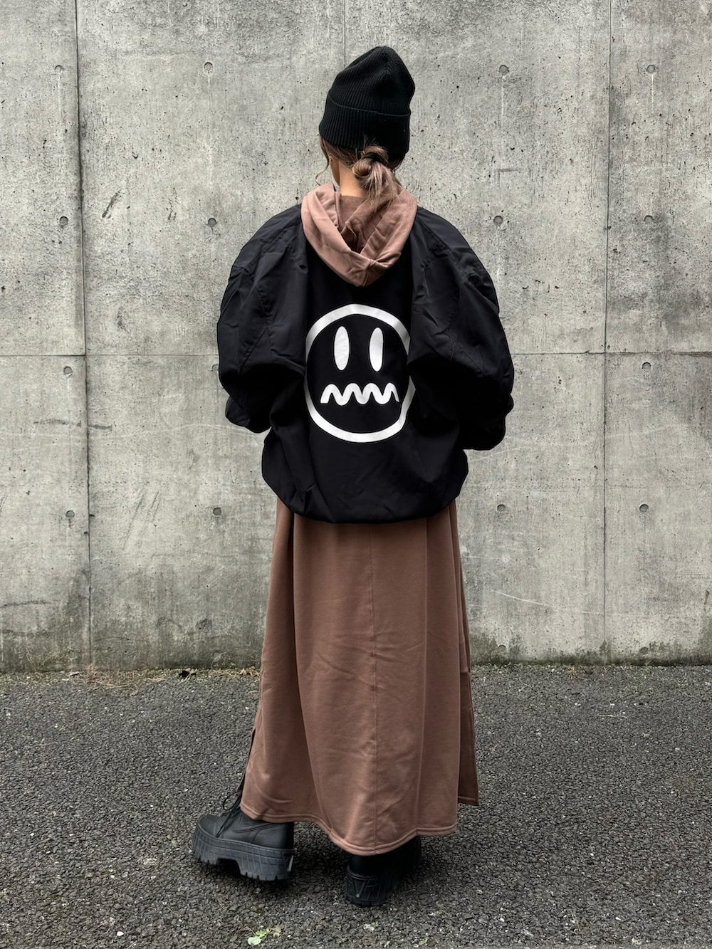 ブラウン系のワンピース、ブラック系のMA-1、ブラック系のスニーカーを着用したレディースの秋コーディネートの3枚目の写真
